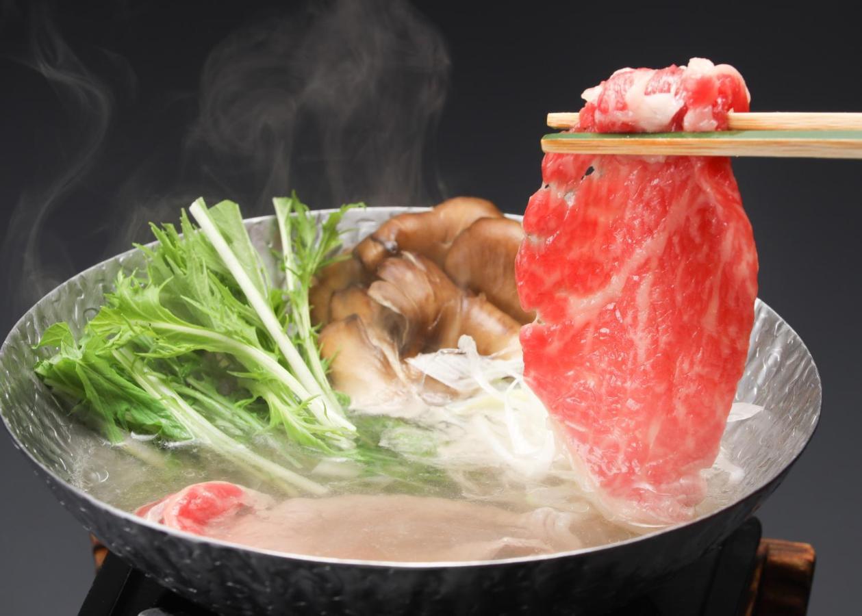 Suimeikan Gero Esterno foto A piece of marbled beef being dipped into a pot of soup